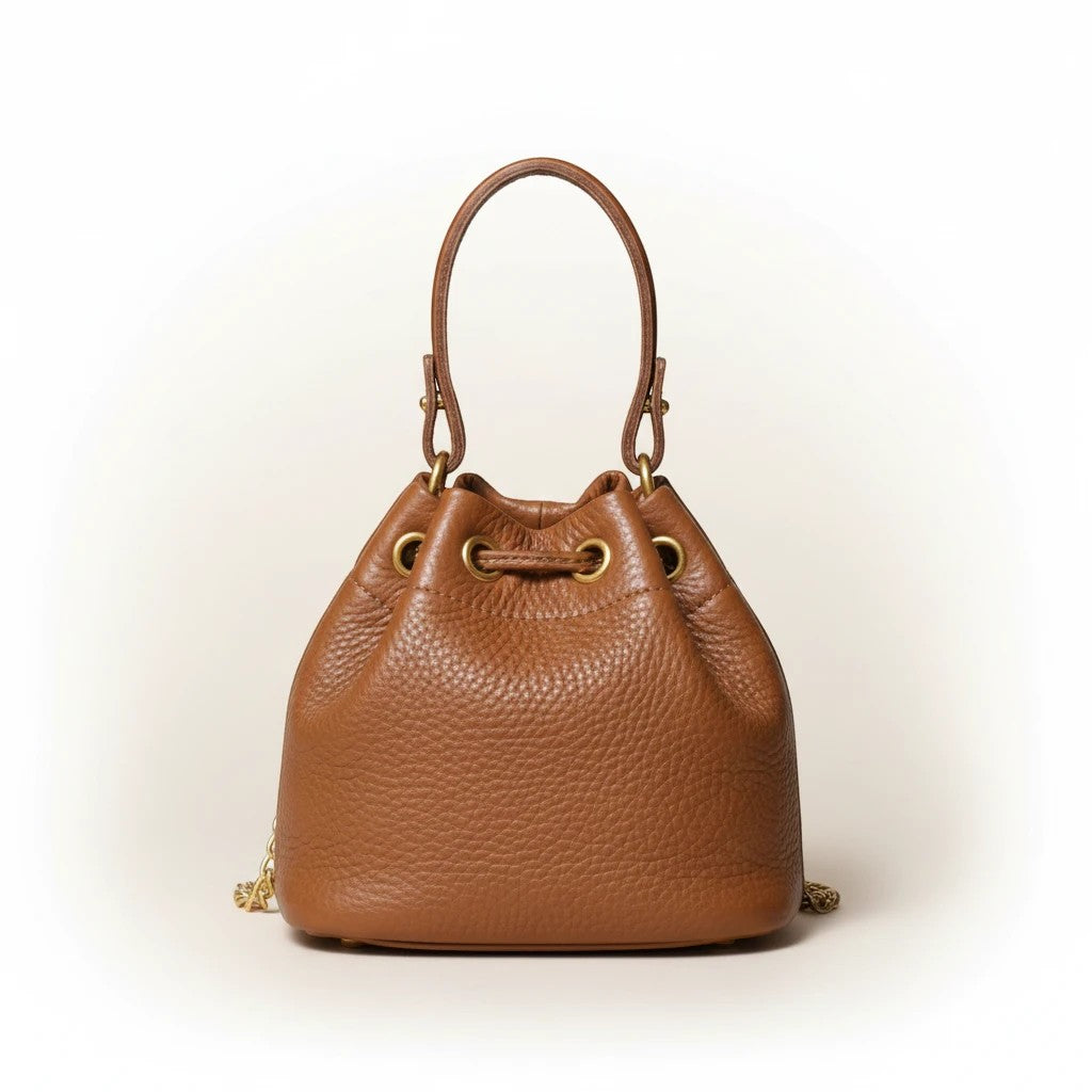 Velmoro Luna vintage genuine leather bucket bag in brown with gold hardware and drawstring closure. Top handle and shoulder strap.