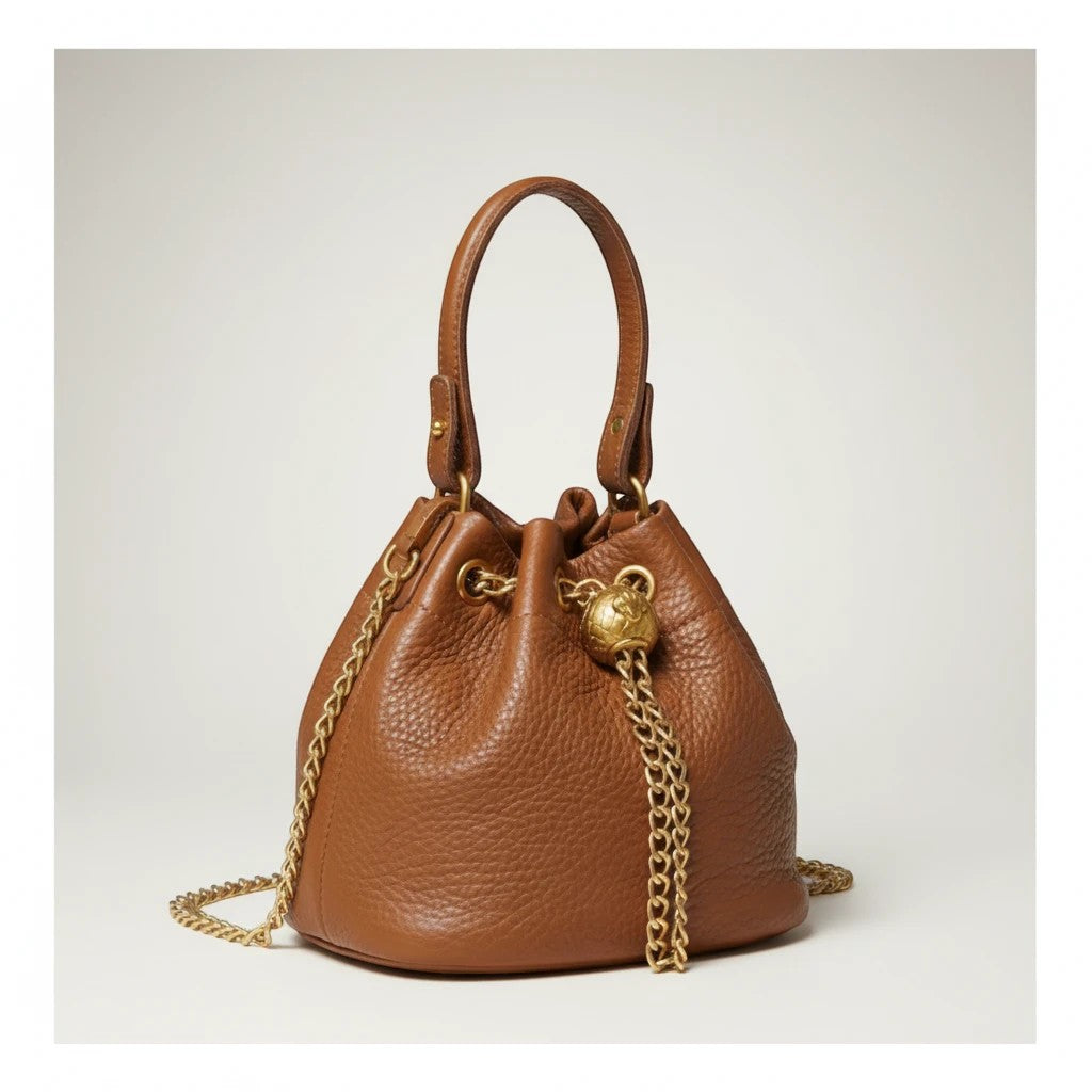 Velmoro Luna vintage genuine leather bucket bag in brown with gold chain detail and drawstring closure.